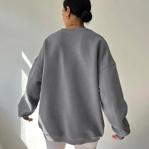 Back view of a grey oversized knitted sweatshirt with ribbed cuffs and crew neck detail