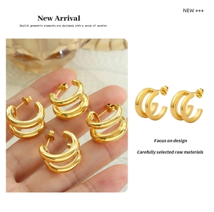 Detailed view of gold double C-shaped earrings showing layered design and glossy finish