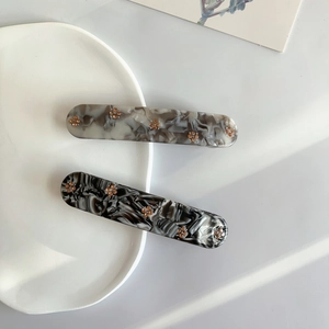 Elegant marble texture hair clips with crystal flower inlay on white ceramic plate