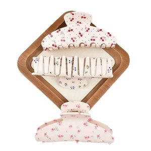 Three-piece floral hair claw clip set with cherry and rose patterns on wooden tray