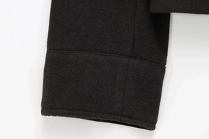 Detailed close-up of smooth sleeve cuff stitching on wool blend women's jacket in dark brown