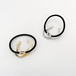 Detail of high-elasticity hair ties with textured gold and silver U-shaped metal buckles