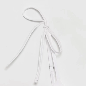 Detail of white elastic shoulder strap with adjustable metal ring on a backless top