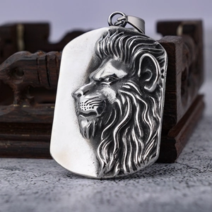 Vintage stainless steel lion head relief pendant necklace on a dark wood jewelry box