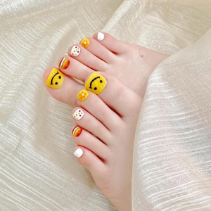 Handmade white press-on toenails with yellow smiley faces and colorful summer flower patterns