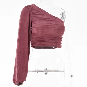 Détail du haut à manche longue asymétrique en tissu rose foncé avec plis froncés