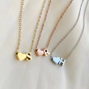 Detailed view of dainty gold, silver, and rose gold necklaces with 3D heart and initial charms.
