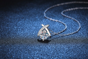 Macro detail of cross design pendant with 1ct moissanite on silver O-chain