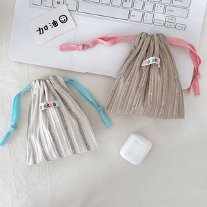 Close-up of striped drawstring pouches for organizing earphones and small accessories