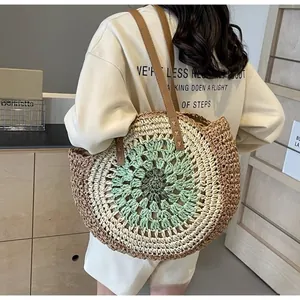 Detail of multi-color circular paper straw beach bag with brown leather straps and stitching