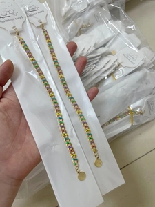 Detail showing colorful enamel links on a gold-plated stainless steel lucky coin bracelet