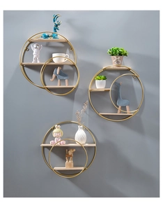 Three-piece gold metal circular floating shelves with wooden planks on a grey wall
