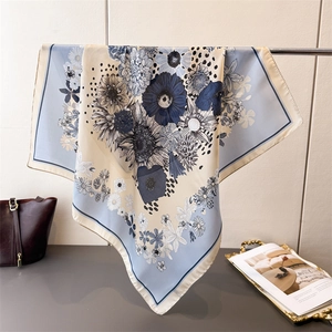 Close-up of elegant floral silk scarf with vintage daisy pattern on a metal rack