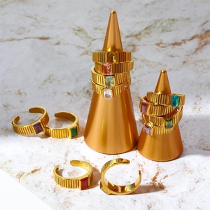 Detailed shot of gold adjustable birthstone rings with textured band on marble