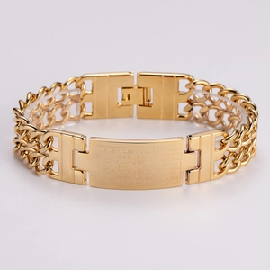 Macro detail of golden double-row Cuban chain bracelet with engraved Spanish prayer