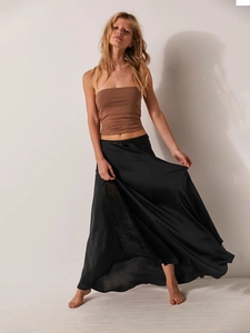 Detail of elegant black satin midi skirt featuring lace splicing and a silky drape finish