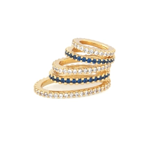 Detailed view of five stacked gold rings with white and blue cubic zirconia settings