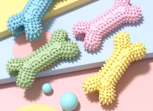 Dettaglio di giocattoli da masticare a forma di osso per cani in colori pastello