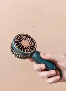 Detail of portable green mini fan with rose gold blades held in hand to show scale