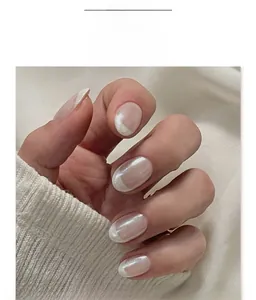 Macro detail of pearlescent French style press-on nails with shimmering white tips