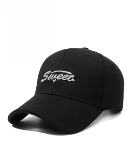 Detail of white Sweet embroidery on a black canvas baseball cap with curved brim