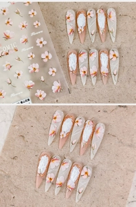 Detailed view of almond-shaped nail stickers with pink flowers and silver foil accents