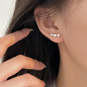 Minimalist 925 sterling silver candy-shaped stud earrings worn on earlobe close-up