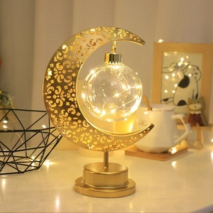 Detail of golden hollow moon lamp with LED glass ball and elegant metal stand