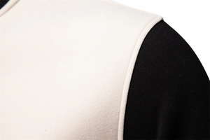 Detail shot of black and beige shoulder stitching and soft knit fabric on sweatshirt
