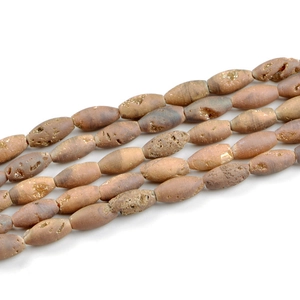 Macro detail of shuttle-shaped natural agate beads with golden crystal textures and pores