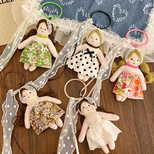 Set of five handmade floral fabric doll keychains with lace details and colorful rings