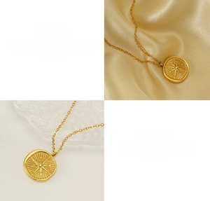 Detailed close-up of 18k gold plated starburst pendant with crystal on satin background