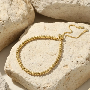 Detail of 18K gold plated beaded bracelet with adjustable slider and zircon accents