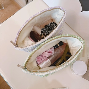 Detail of tweed makeup bags with metal zippers in lavender and light green colors
