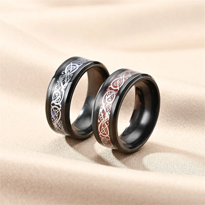 Detailed macro view of black stainless steel rings with blue and red celtic knot patterns
