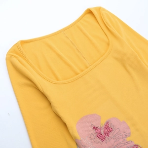 Dettaglio dell'abito in maglia a coste con scollo a U, fiori e strass luccicanti