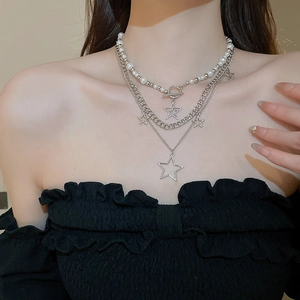 Close-up of layered silver star necklace with pearls on neck for fashion styling