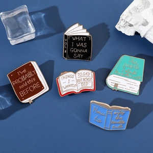 Detailed close-up of colorful book-shaped enamel pins with creative English quotes