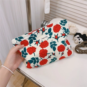 Detail showing vintage red rose floral pattern on cotton makeup bag with white label