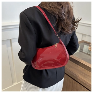 Red patent leather hobo bag with gold hardware shown as a shoulder bag on a model