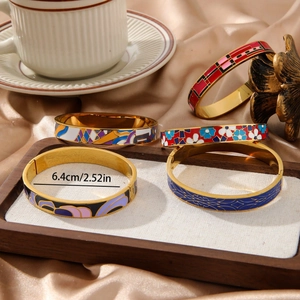 Detail of colorful enamel bracelets with geometric patterns on a gold metal base