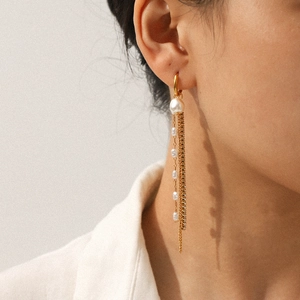 Eleganti orecchini lunghi a nappa dorati con perle bianche e catene di strass lucidi