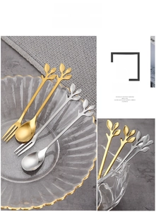 Detail of leaf-shaped handle on gold and silver stainless steel dessert spoons and forks