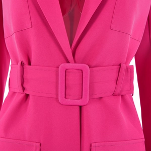 Détail du blazer rose fuchsia avec ceinture à boucle rectangulaire et poches plaquées