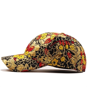 Dettaglio dell'intricato ricamo floreale oro e rosso su cappellino hip hop in cotone