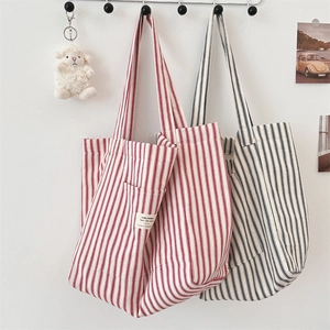 Detail of red and navy striped canvas tote bags showing fabric texture and labels
