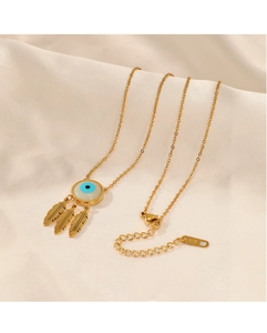 Detail of K18 gold evil eye necklace with three metal feather pendants on silk background