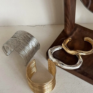 Irregular wide open gold and silver arm cuffs with layered wire and lava texture designs