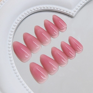 Pink cat eye almond press-on nails with pearl gradient finish arranged on a mirror