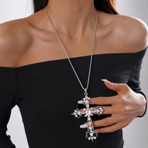 Close-up of model wearing a vintage silver cross pendant with pink gemstone and rhinestones
